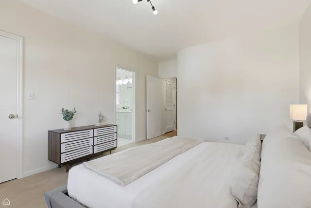 a bedroom with a bed and a potted plant