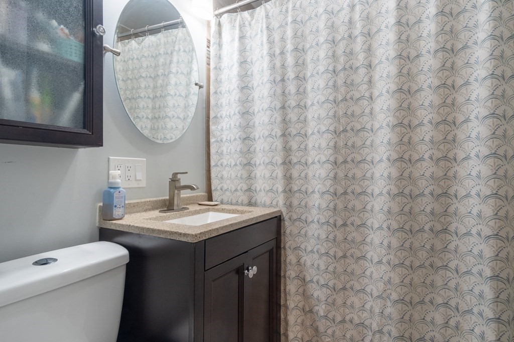 55 Lyman Street West Springfield, MA 01089 - Photo 16 of 24 a bathroom with a granite countertop sink a toilet and a mirror