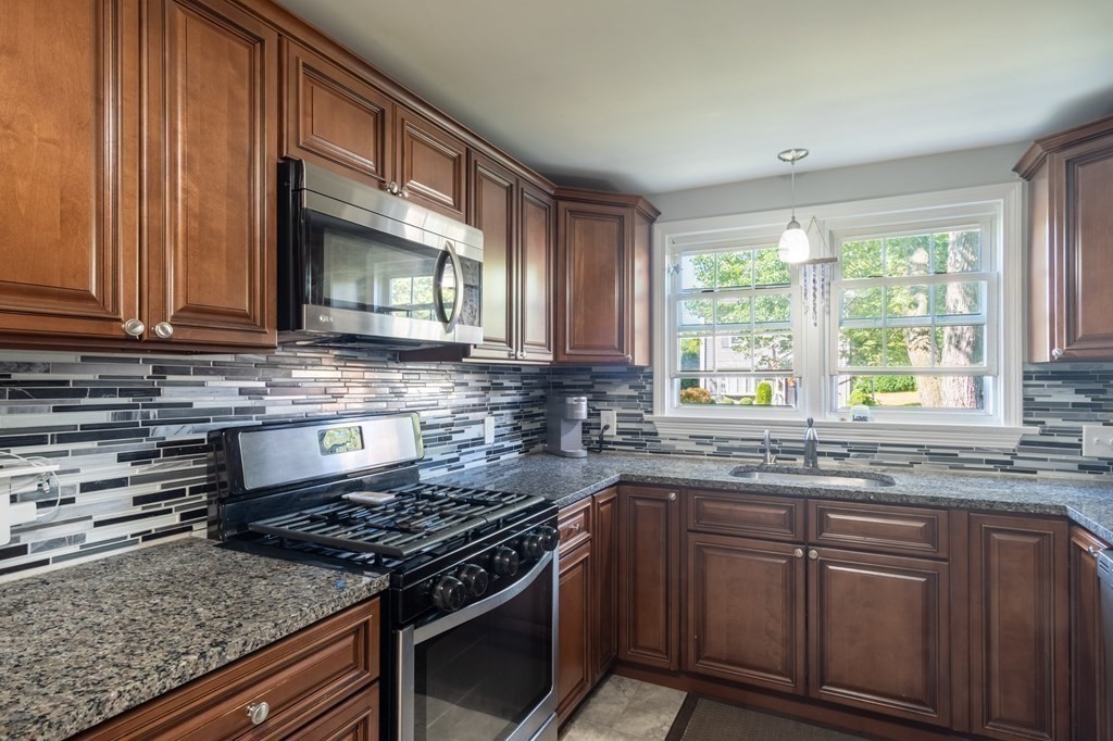 55 Lyman Street West Springfield, MA 01089 - Photo 7 of 24 a kitchen with stainless steel appliances granite countertop a stove a sink and a microwave