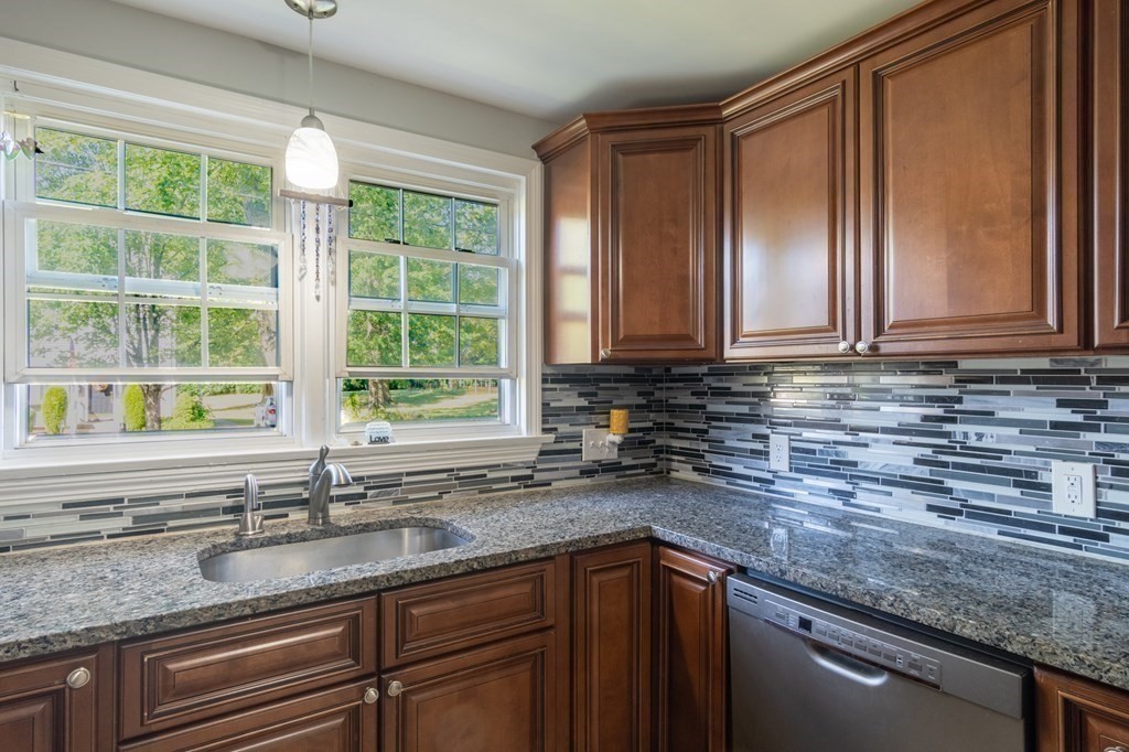 55 Lyman Street West Springfield, MA 01089 - Photo 8 of 24 a kitchen with granite countertop a sink window and cabinets
