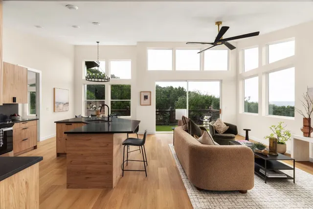 a living room with furniture a flat screen tv and a large window