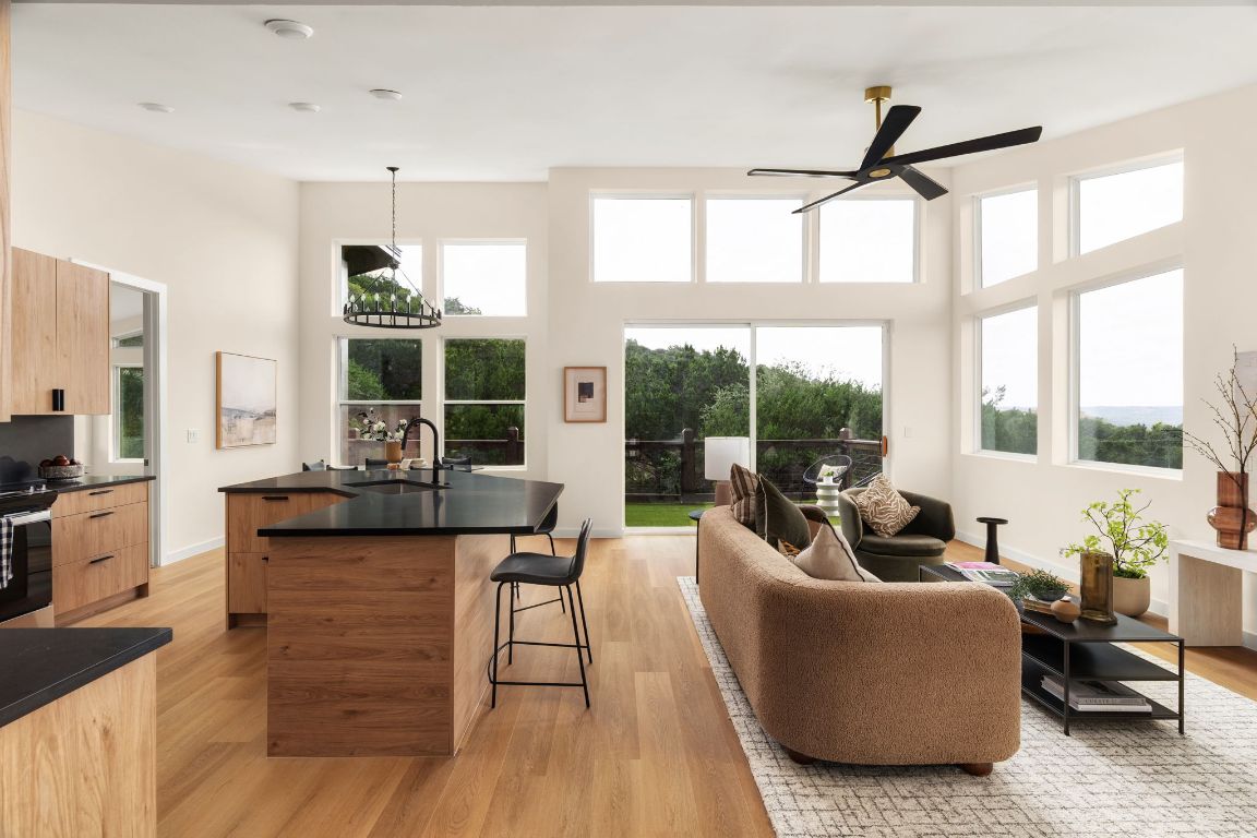a living room with furniture a flat screen tv and a large window