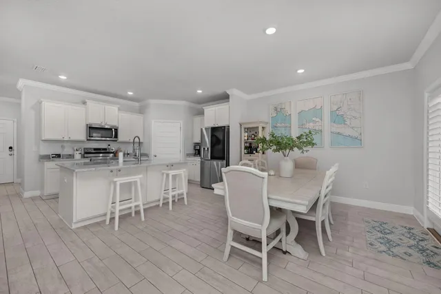 a kitchen with a dining table chairs stainless steel appliances and cabinets