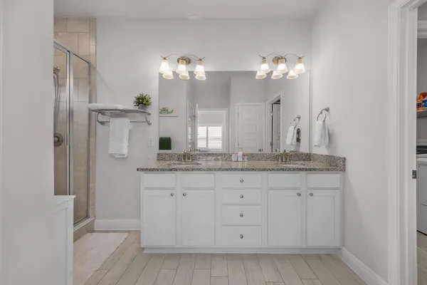 a bathroom with a granite countertop sink a mirror and a shower