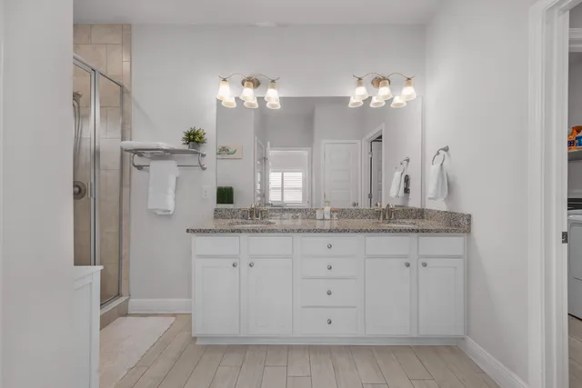 a bathroom with a granite countertop sink a mirror and a shower