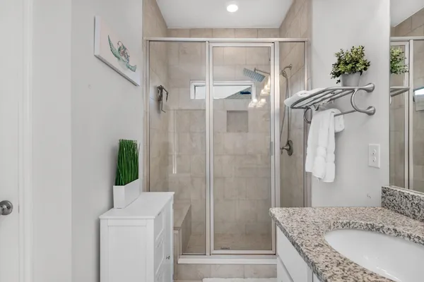 a bathroom with a granite countertop shower sink and mirror