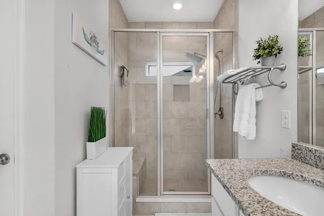 a bathroom with a granite countertop shower sink and mirror