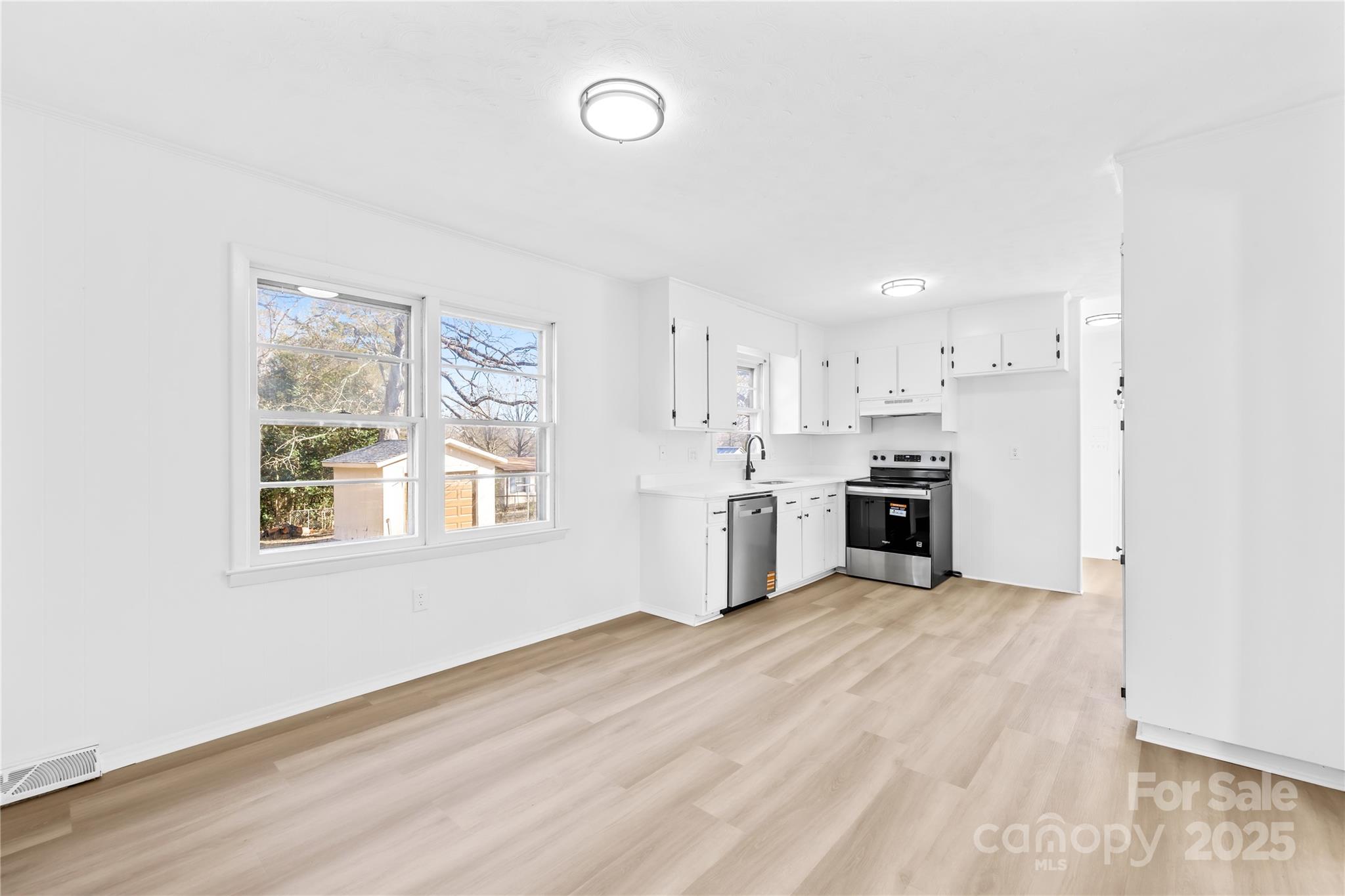 2405 Florida Avenue Kannapolis, NC 28083 - Photo 6 of 38 a large white kitchen with stainless steel appliances granite countertop a stove and a sink