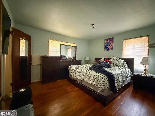 a bedroom with a bed and wooden floor
