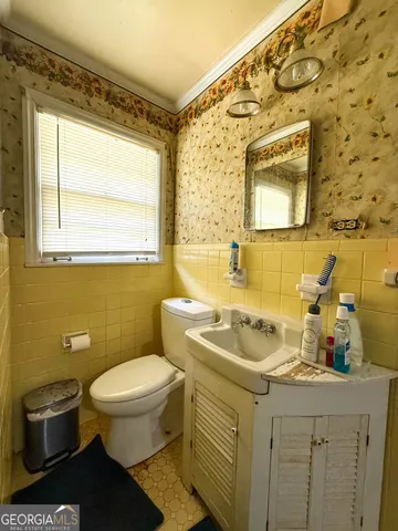 a bathroom with a sink a toilet and a mirror