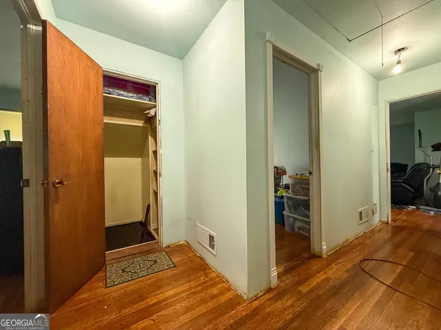 a view of a hallway with bathroom and wooden floor