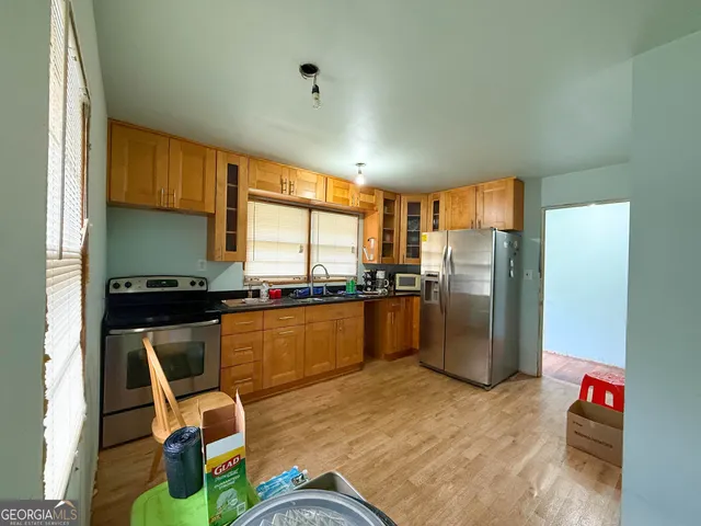 a kitchen with stainless steel appliances granite countertop a refrigerator and a stove top oven