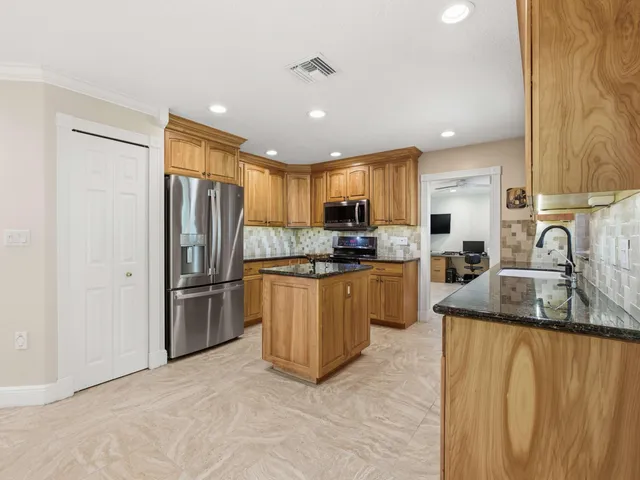 a kitchen with granite countertop sink window and chairs