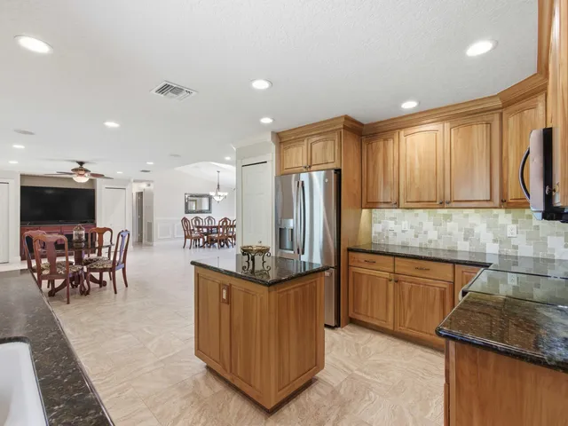an empty room with windows and ceiling fan