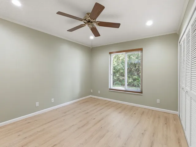 wooden floor & ceiling fan in a room