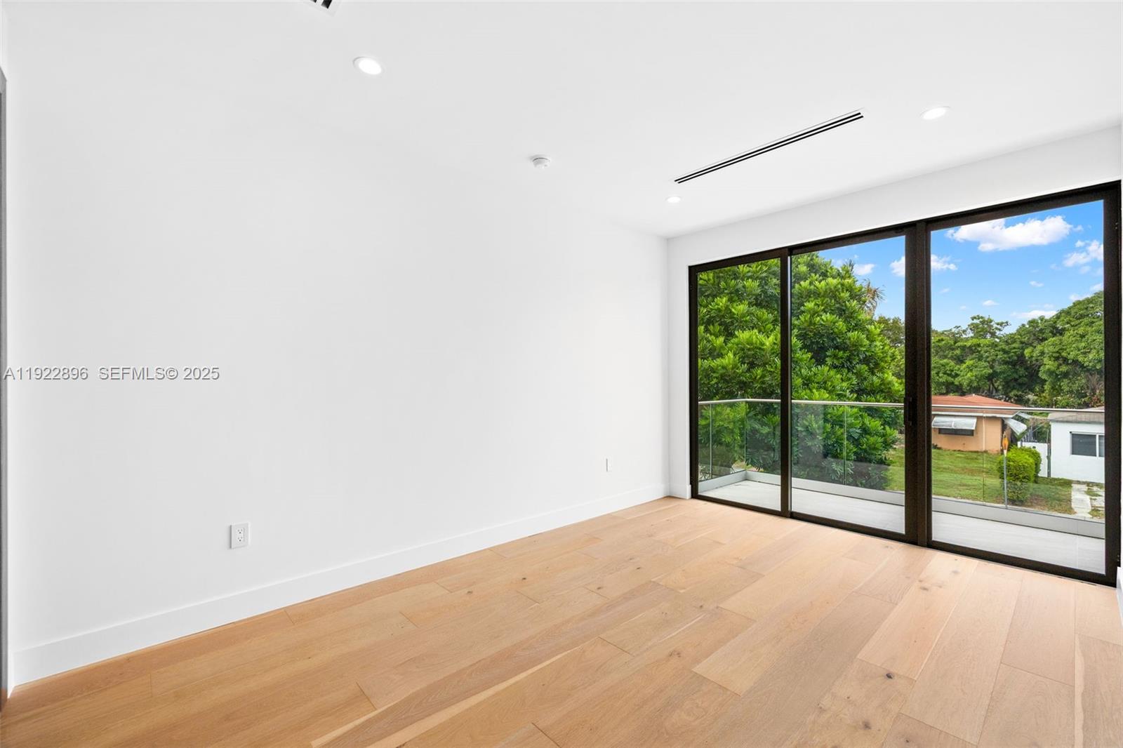 66 Northwest 50th Street Miami, FL 33127 - Photo 46 of 60 an empty room with wooden floor and windows