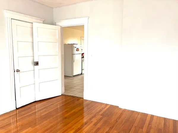 a view of empty room with wooden floor