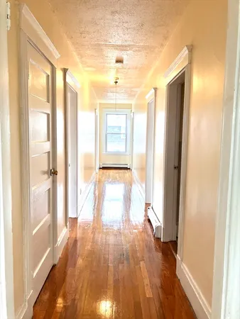 a view of a room with wooden floor and a window