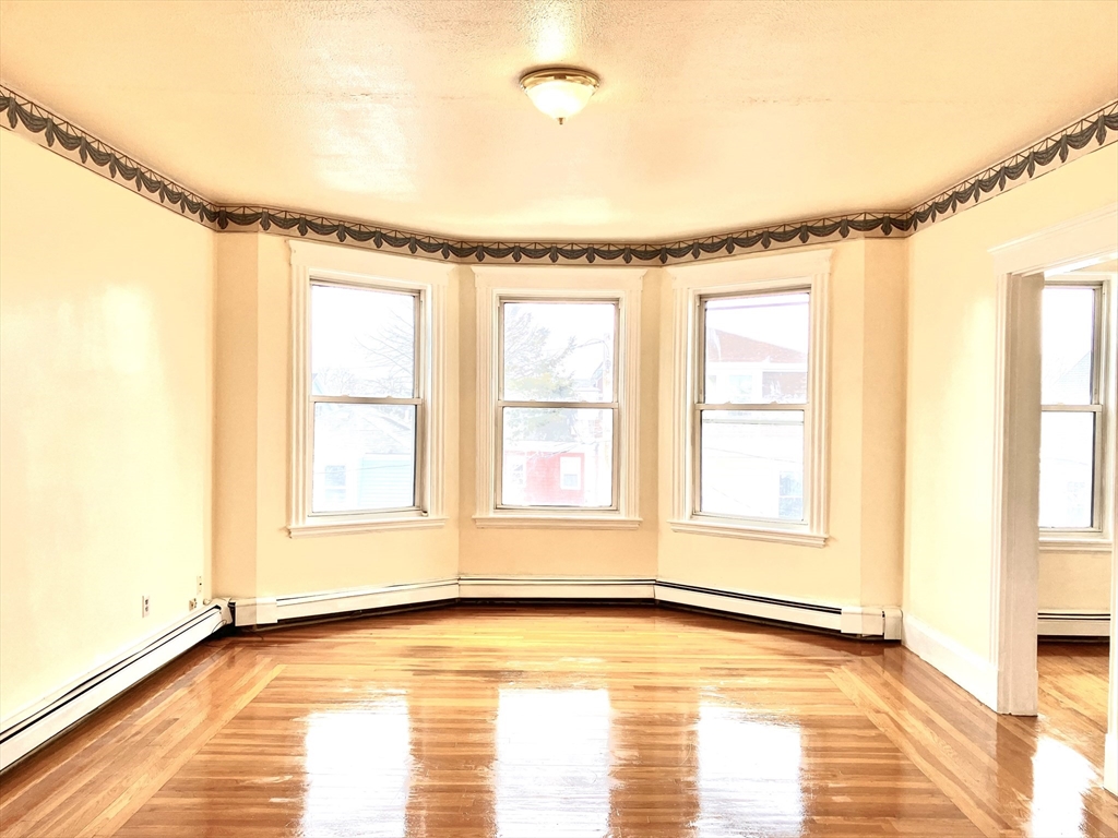 41 Brimblecom Street, Unit 3 Lynn, MA 01902 - Photo 3 of 16 a view of an empty room with a window and wooden floor