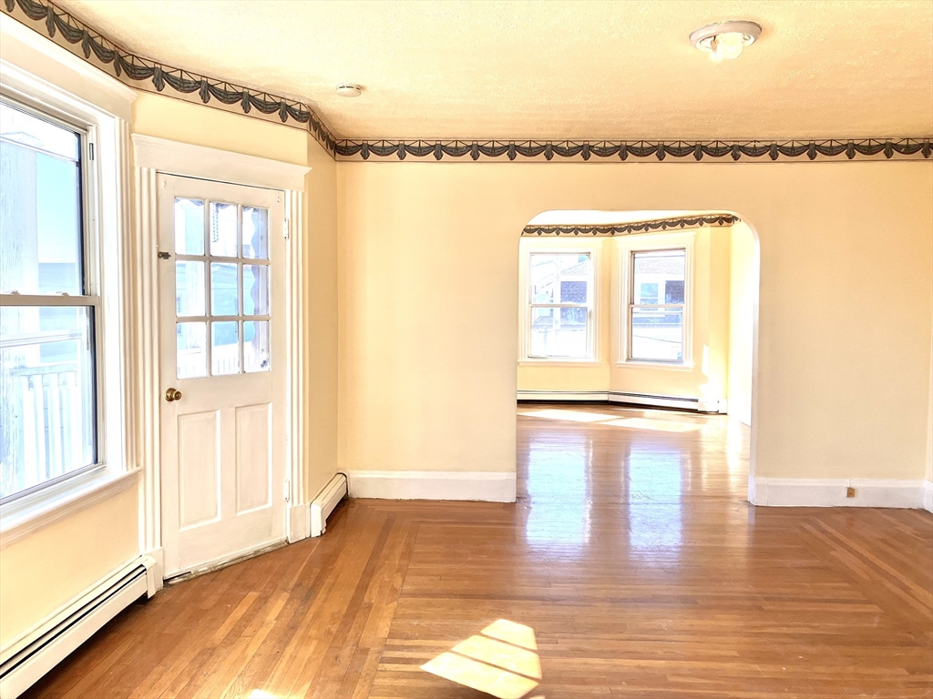 41 Brimblecom Street, Unit 3 Lynn, MA 01902 - Photo 6 of 16 a view of a room with a large window and wooden floor