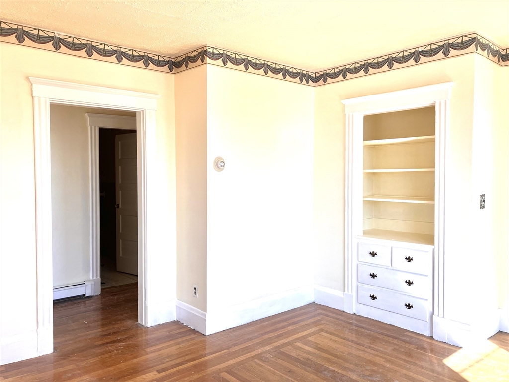 41 Brimblecom Street, Unit 3 Lynn, MA 01902 - Photo 7 of 16 a view of a bedroom with closet and wooden floor