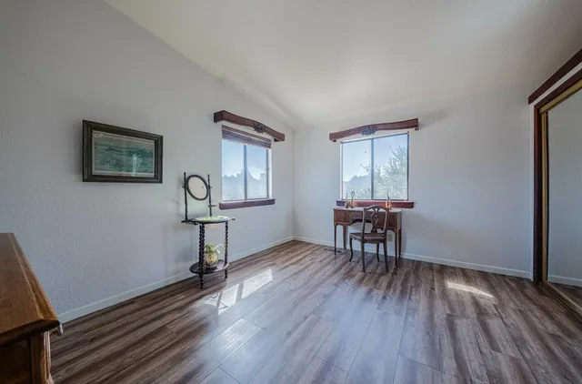 a view of a bedroom with furniture and wooden floor