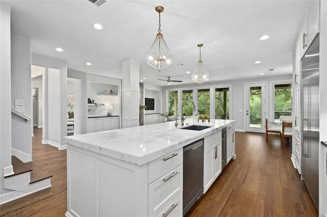 a large kitchen with kitchen island a large island in it