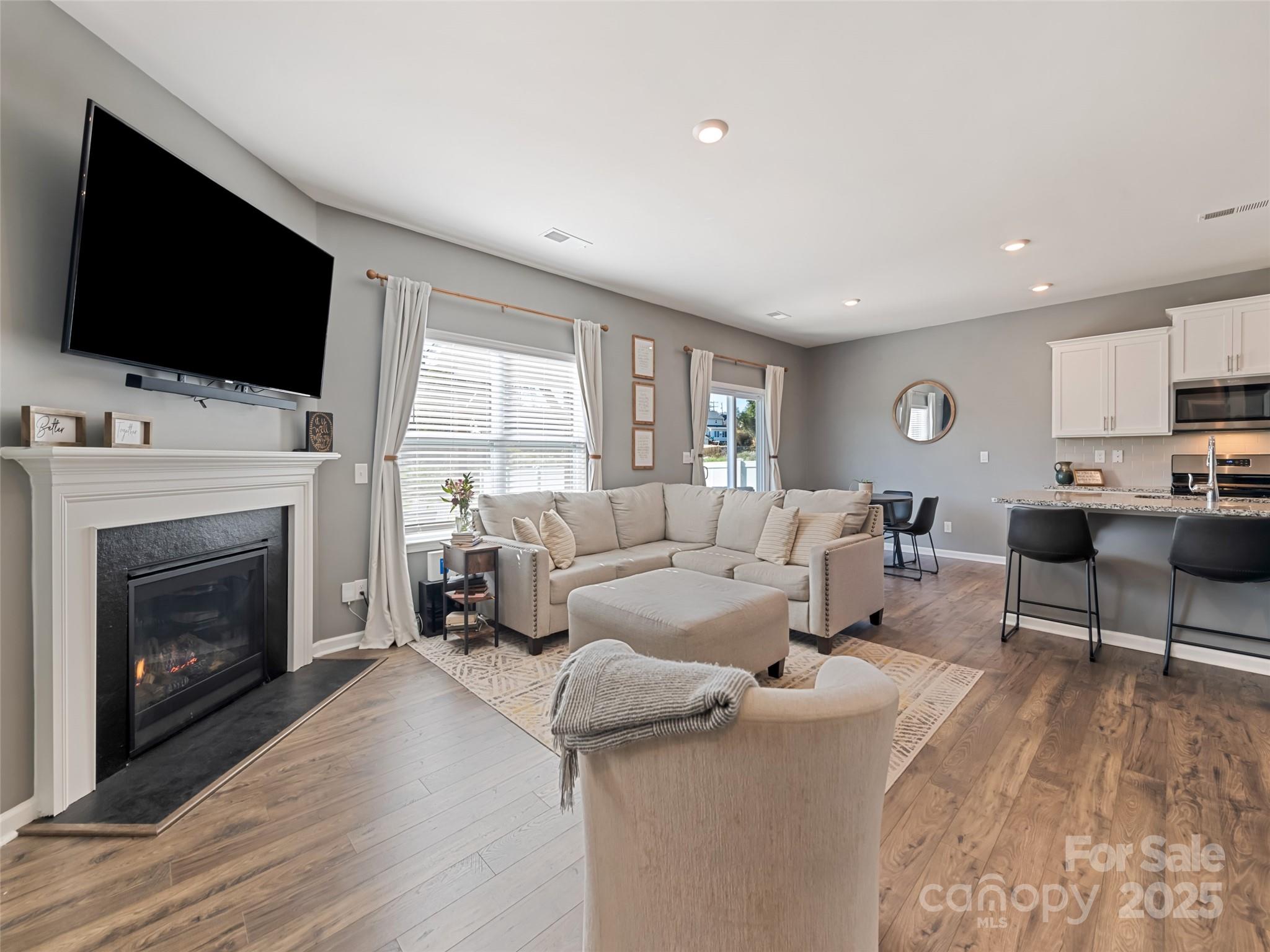 128 Wheatfield Road Fletcher, NC 28732 - Photo 6 of 44 a living room with furniture a fireplace and a flat screen tv