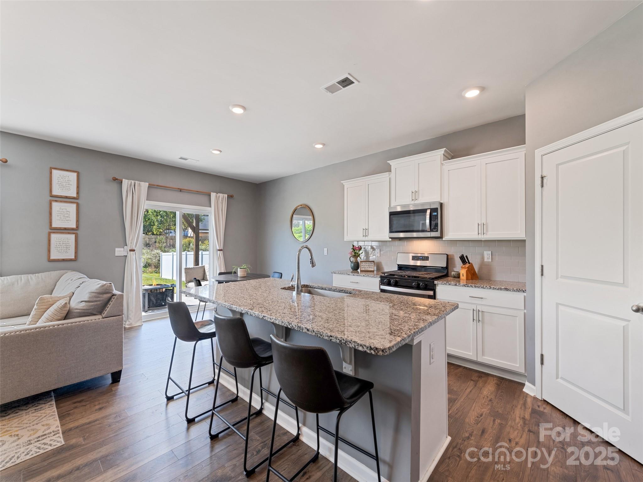128 Wheatfield Road Fletcher, NC 28732 - Photo 10 of 44 a kitchen with a table chairs microwave and cabinets