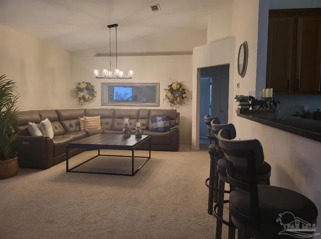 a living room with furniture a chandelier and a flat screen tv