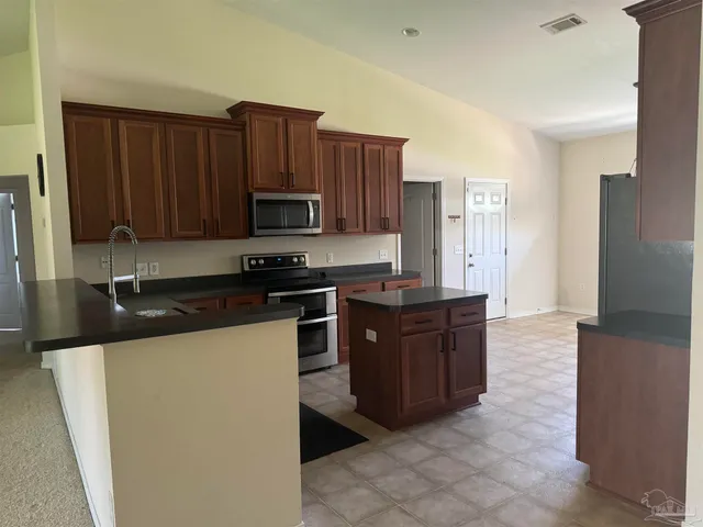 a kitchen with stainless steel appliances granite countertop a refrigerator stove a sink and dishwasher