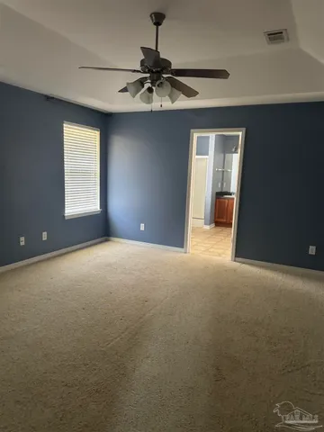 a view of a room with a ceiling fan and window