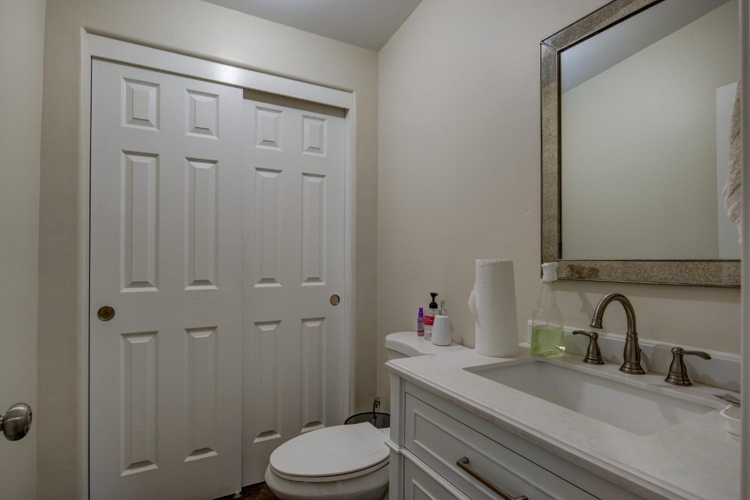 Undisclosed Address Somerset, CA 95684 - Photo 35 of 90 a bathroom with a granite countertop sink a toilet and shower