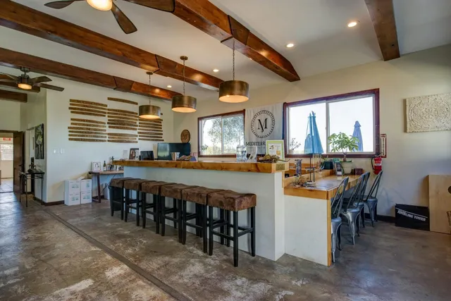 a large dining space with furniture a rug and chandelier