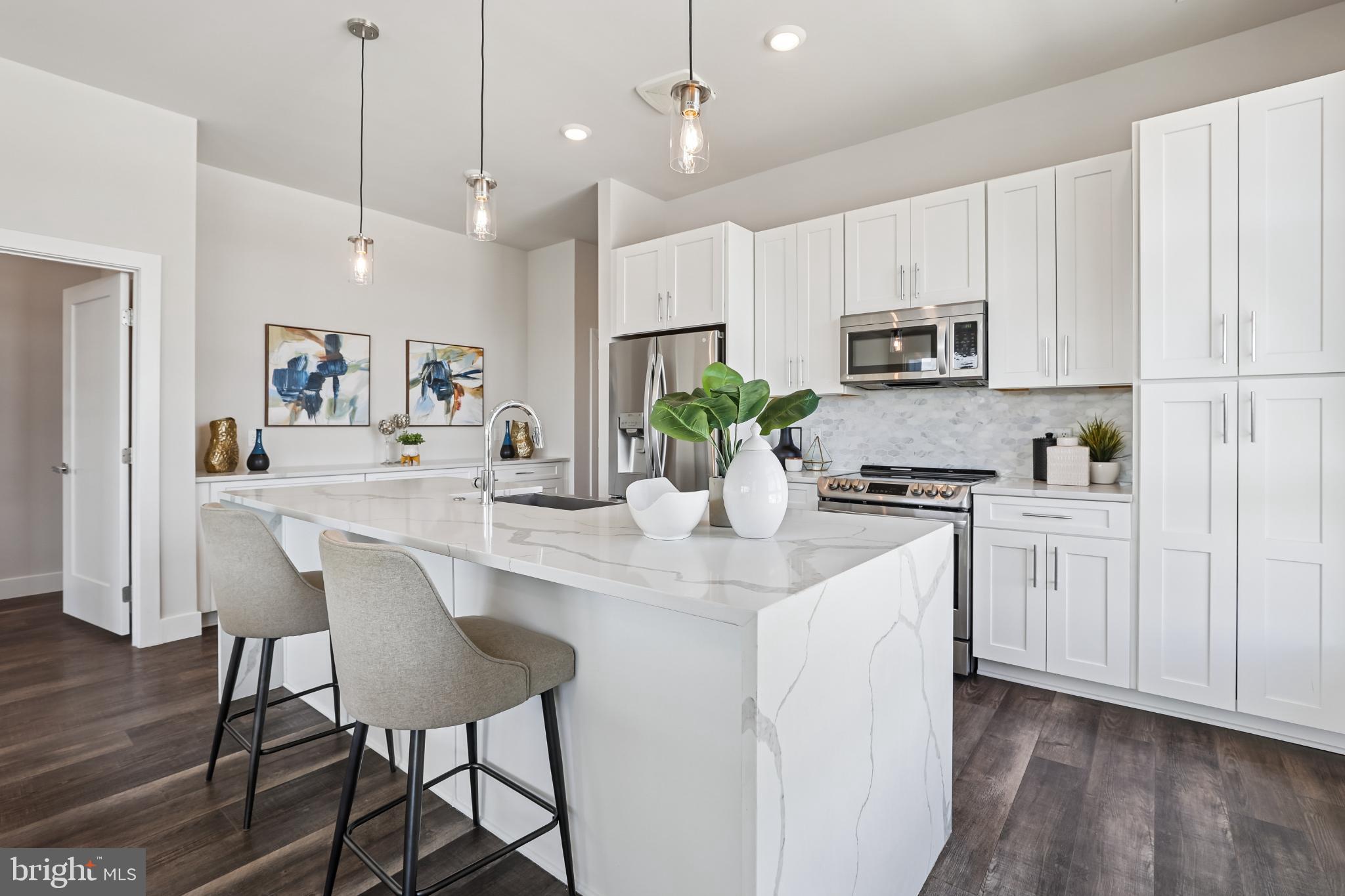 1761 Old Meadow Road, Unit 517 McLean, VA 22102 - Photo 5 of 39 a kitchen with kitchen island white cabinets and white appliances