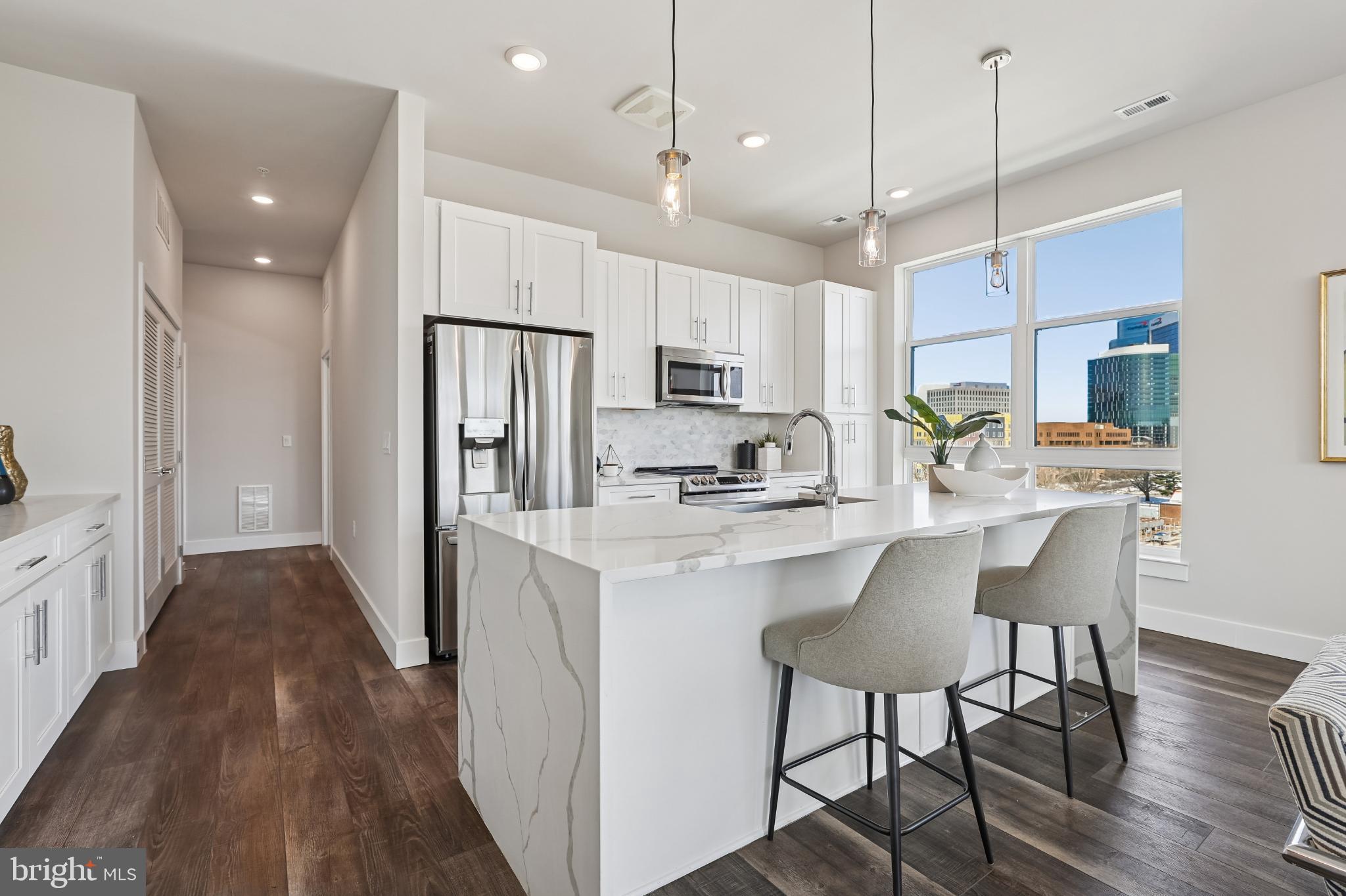 1761 Old Meadow Road, Unit 517 McLean, VA 22102 - Photo 6 of 39 a kitchen with kitchen island a wooden floor and white appliances