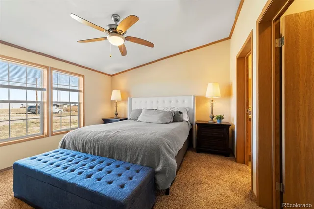 a bedroom with a bed and a window with a chandelier