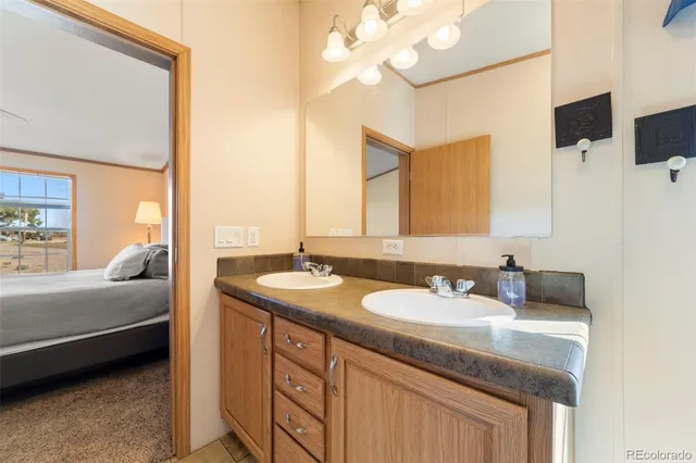 a en suite bathroom with a double vanity sink and a mirror