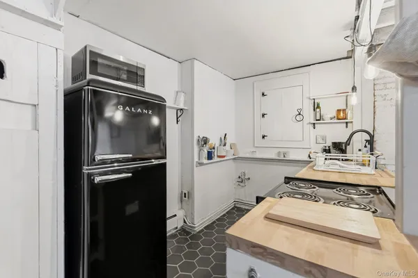 a kitchen with granite countertop a refrigerator stove and sink