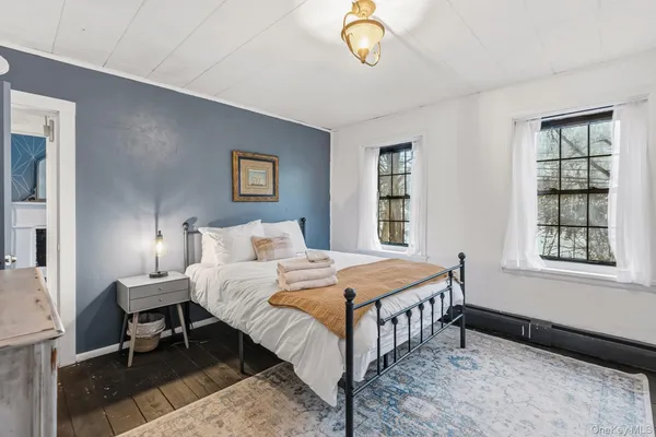 a bedroom with a bed a chandelier and dresser