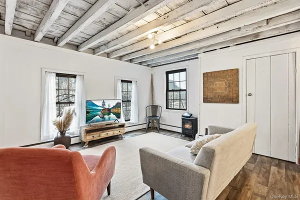 a living room with furniture floor to ceiling window and a flat screen tv