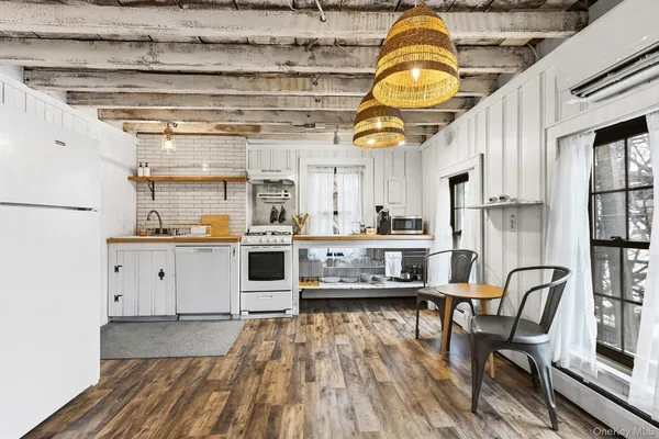 a kitchen with stainless steel appliances granite countertop a wooden floor and white cabinets