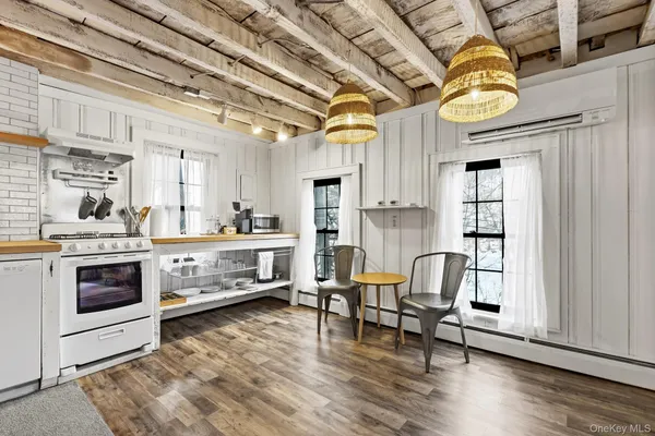 a living room with stainless steel appliances kitchen island granite countertop furniture and a wooden floor
