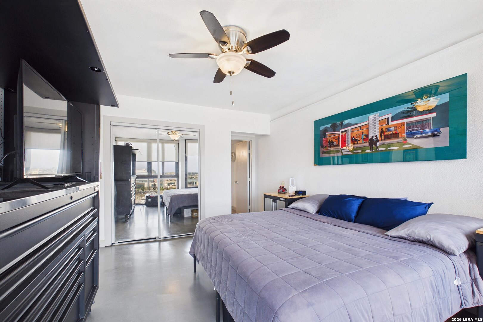 7701 Wurzbach Road, Unit 1803 San Antonio, TX 78229 - Photo 21 of 34 a bedroom with a large bed and a chandelier