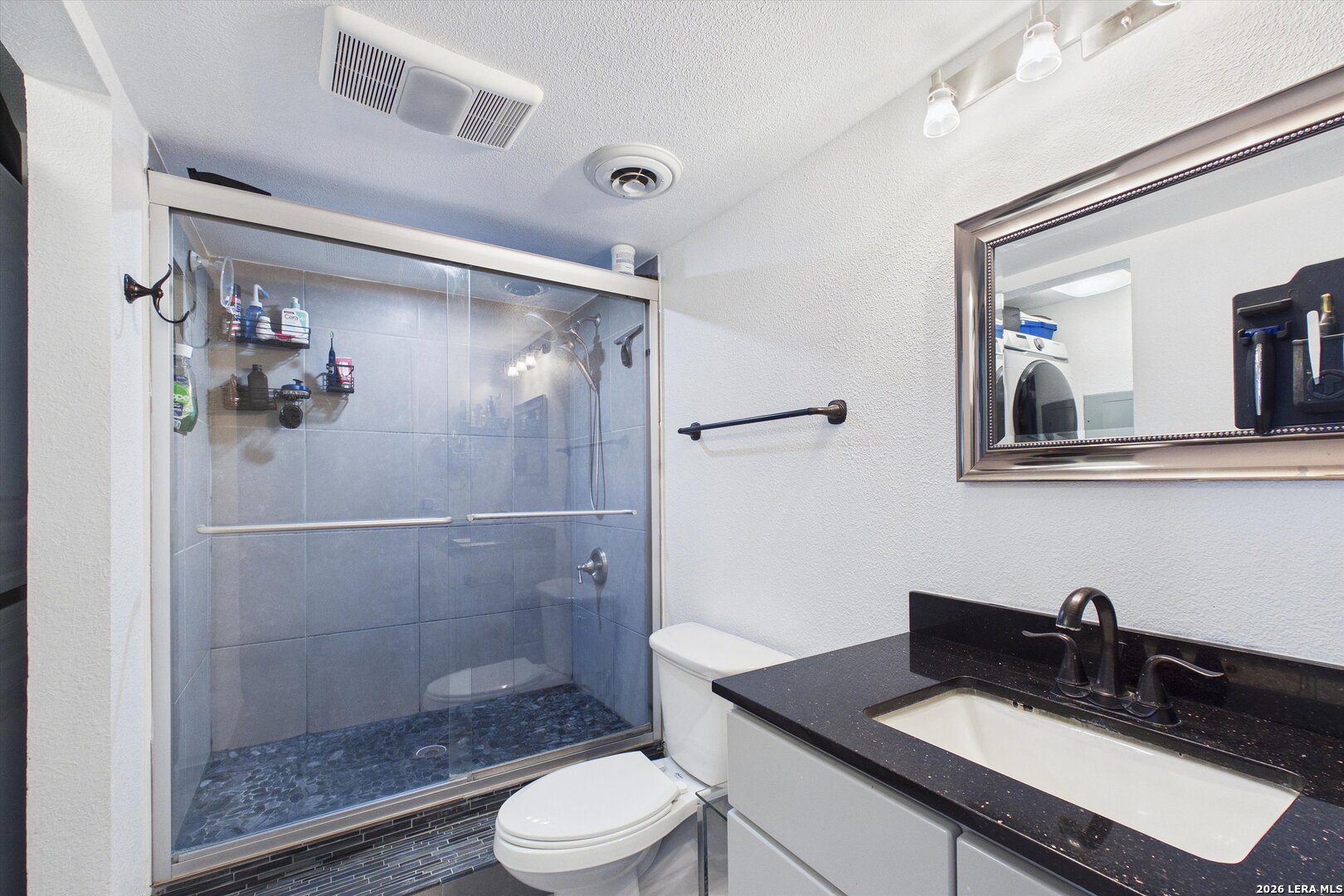 7701 Wurzbach Road, Unit 1803 San Antonio, TX 78229 - Photo 23 of 34 a bathroom with a sink toilet a mirror and shower