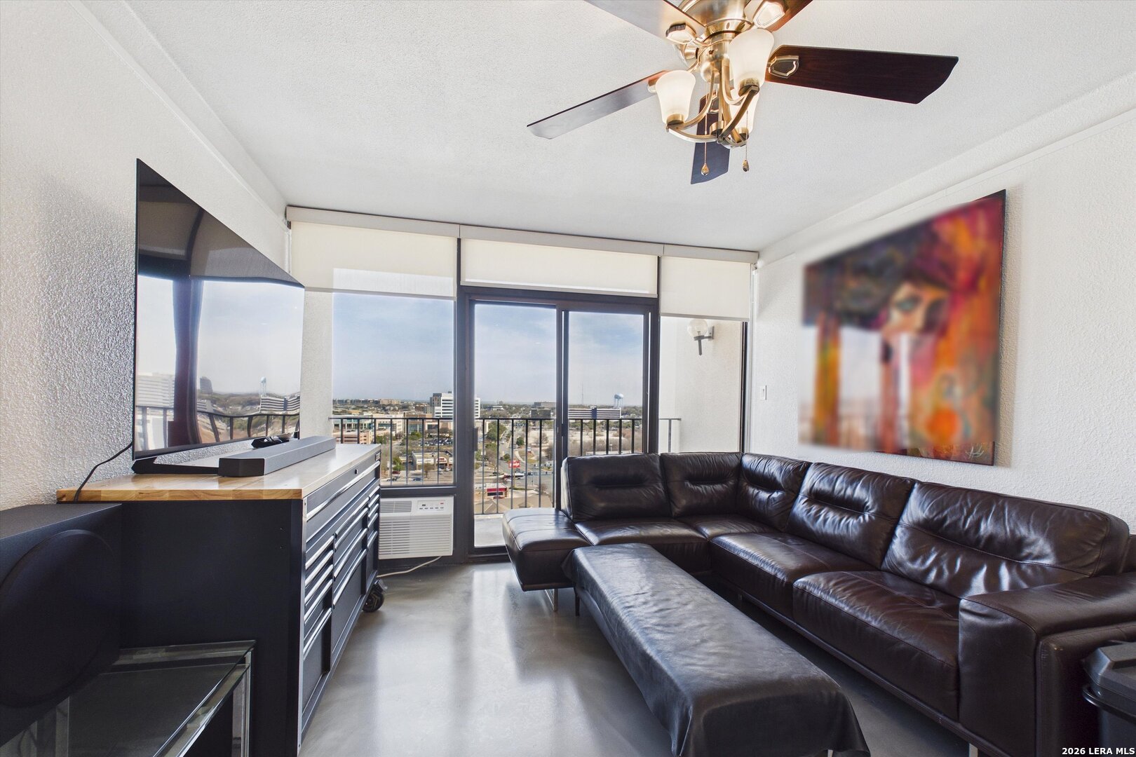 7701 Wurzbach Road, Unit 1803 San Antonio, TX 78229 - Photo 9 of 34 a living room with furniture ceiling fan and a large window