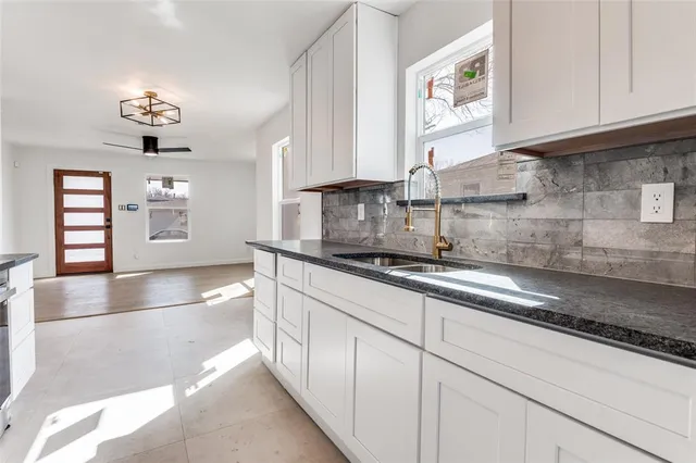 a kitchen with stainless steel appliances granite countertop a sink a stove and cabinets