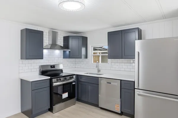 a kitchen with stainless steel appliances a sink stove and refrigerator