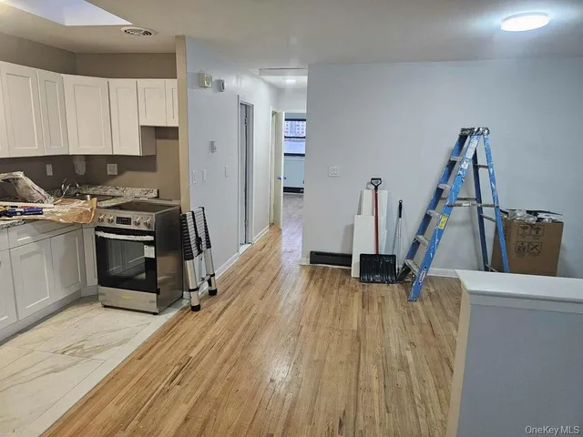 a view of a kitchen with a sink wooden floor and stainless steel appliances