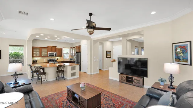 a dining hall with stainless steel appliances granite countertop a stove top oven a sink dishwasher a dining table and chairs with wooden floor